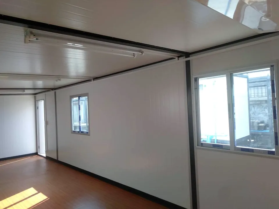 Modular interior corner with a sliding window, fluorescent light and timber-look floor.